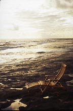 Deck chair on rocky beach, Long Island, Bahamas Out Islands